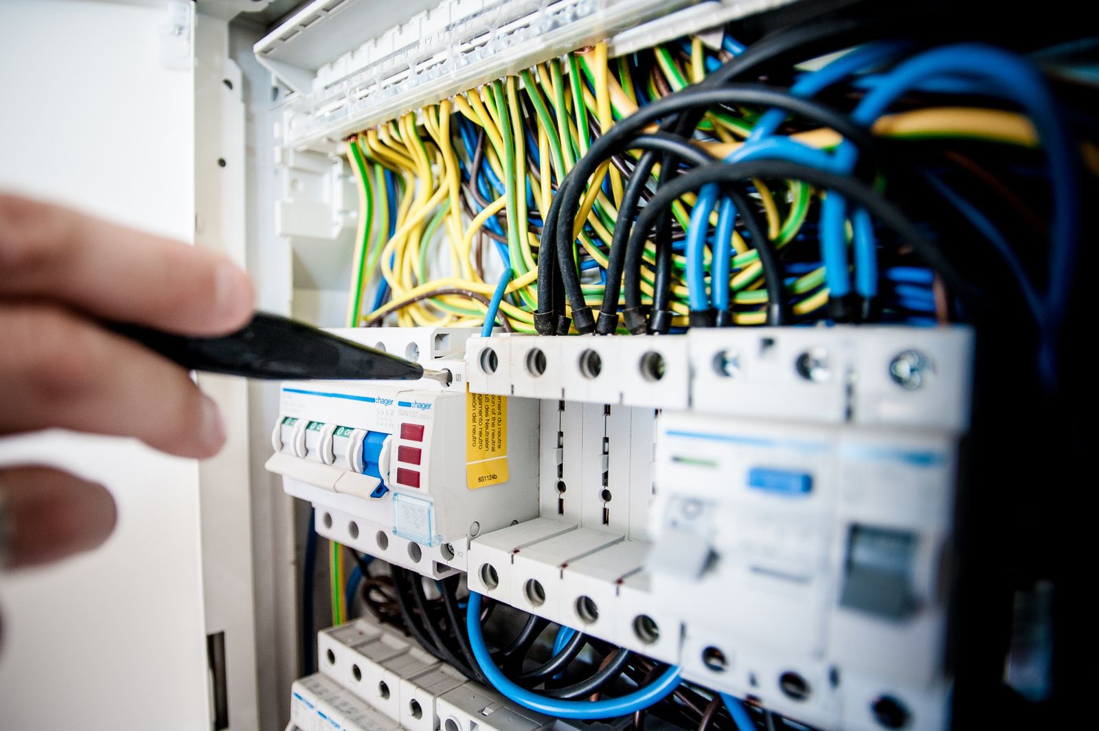 Licensed electrician working in an open electrical panel